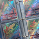 A photograph from my son's Pokemon card binder, showing a bunch of rainbow rares and what I'm pretty sure is a fake ultra rare Charizard GX.
